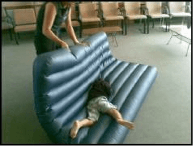 Child being rolled around on an airbed by O&amp;amp;amp;amp;amp;M instructor.