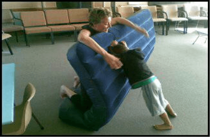 O &amp;amp; M instructor holding up an airbed while child pushes against the airbed from the other side.