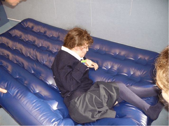 Sam is leaning on her left elbow and the O &amp;amp; M Instructor is lifting the corner of the airbed.