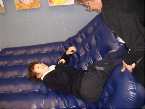 Sam is lying on their airbed pushing the O &amp;amp;amp;amp;amp; M Specialist away with the legs.