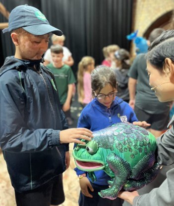 An actor describing a soft toy frog, a prop used in the TWITS performance.