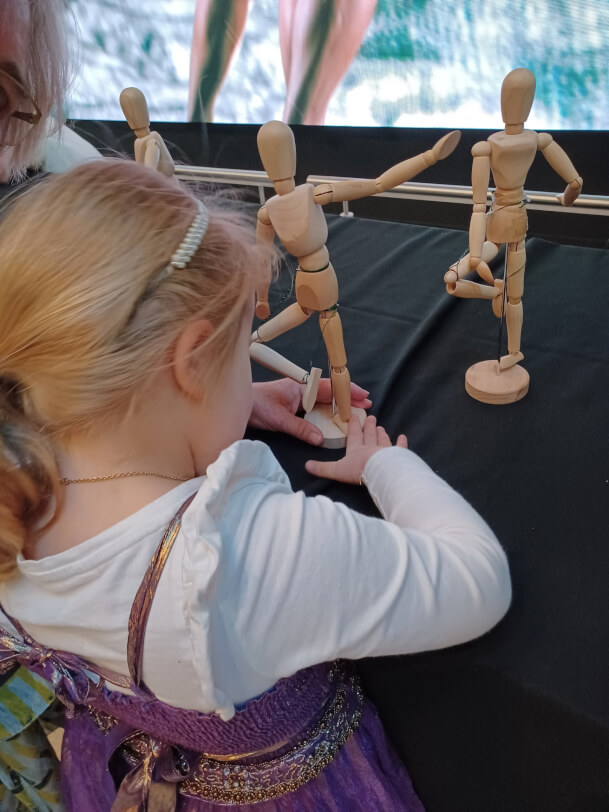 Child holding a wooden ballet figure.