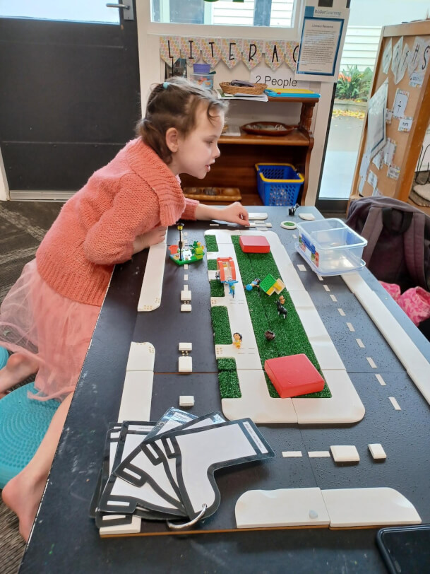 Child is exploring a Wise Walker raod map on a table rotated